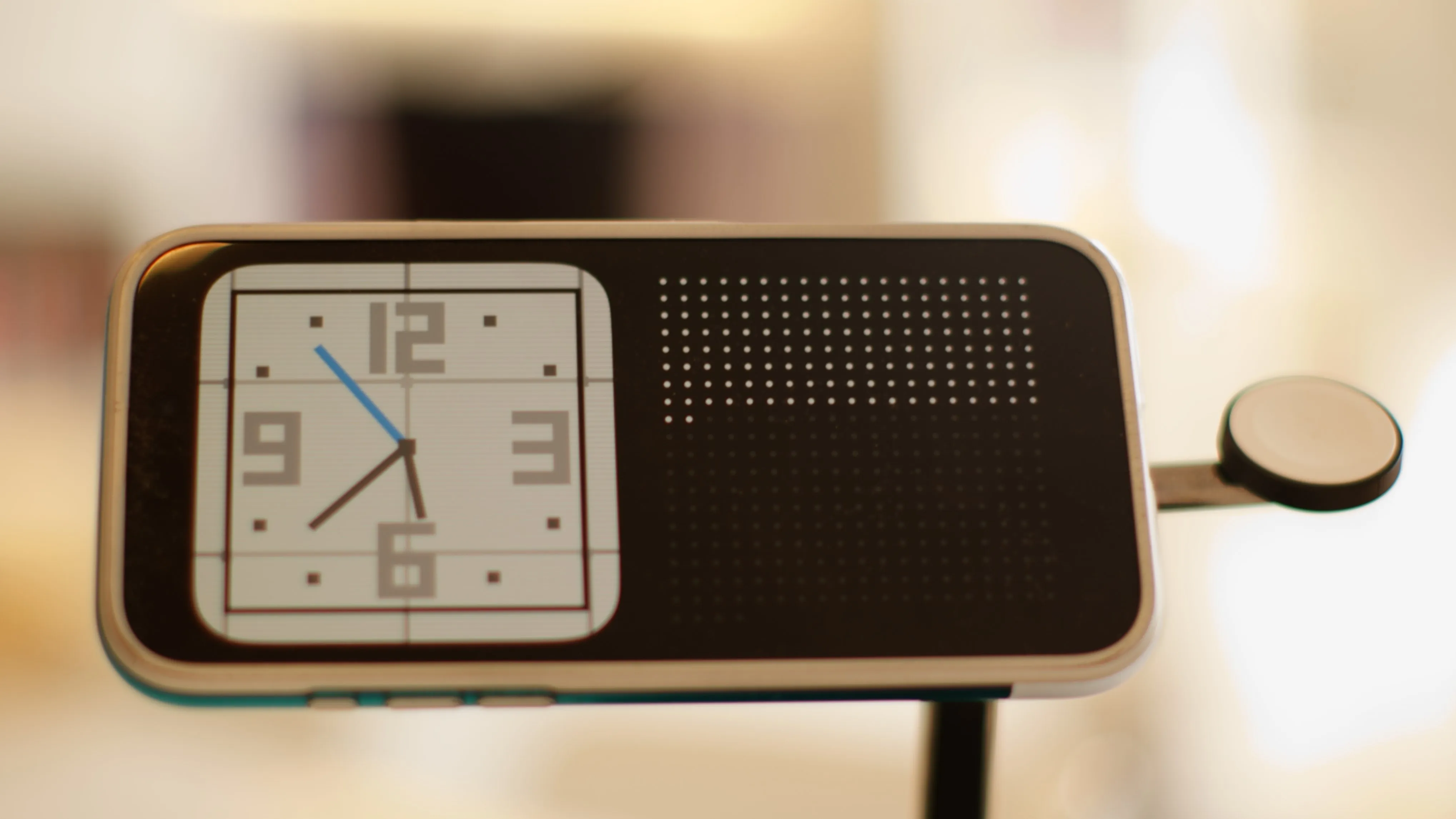 an iPhone on StandBy mode, showing a clock widget themed after the Nintendo DS clock alongside a widget showing a grid of 365 dots, where the first 154 are filled in and the rest are gray.